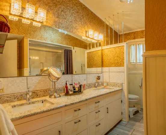 a bathroom with a granite countertop sink vanity mirror and toilet