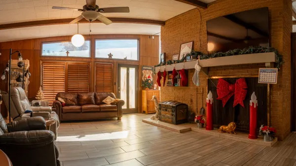 a living room with furniture a ceiling fan and a window