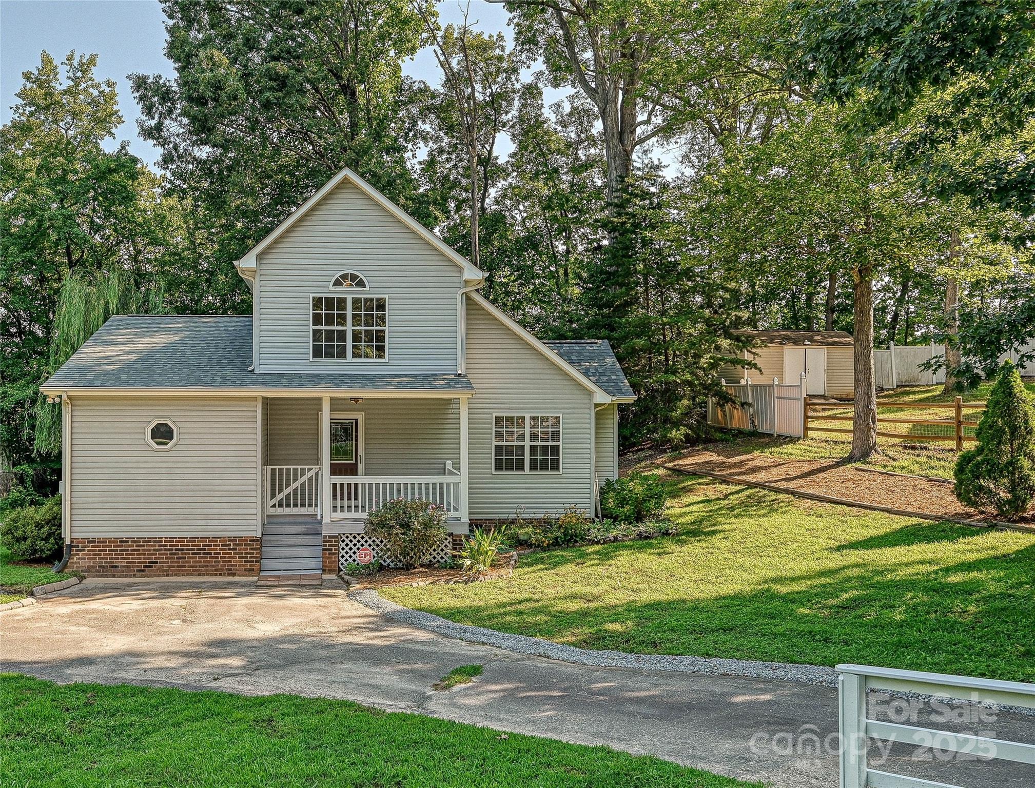 a front view of house with yard and trees around