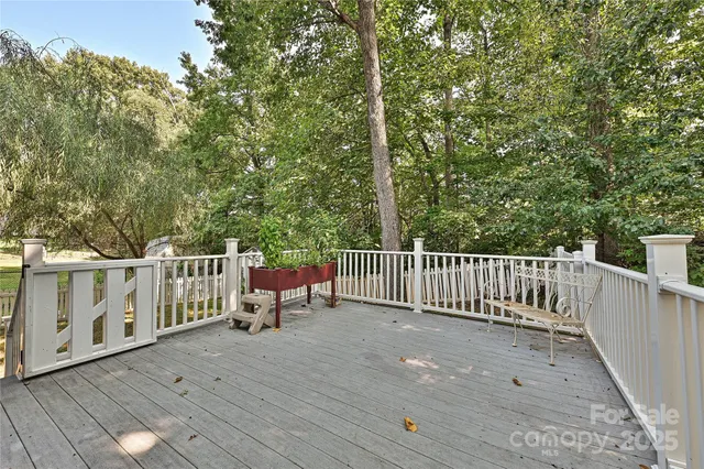 a view of a deck with two chairs and wooden fence