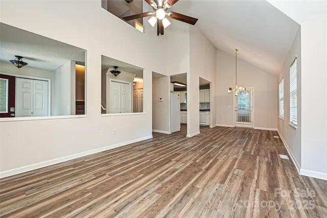 a view of an empty room with window and wooden floor