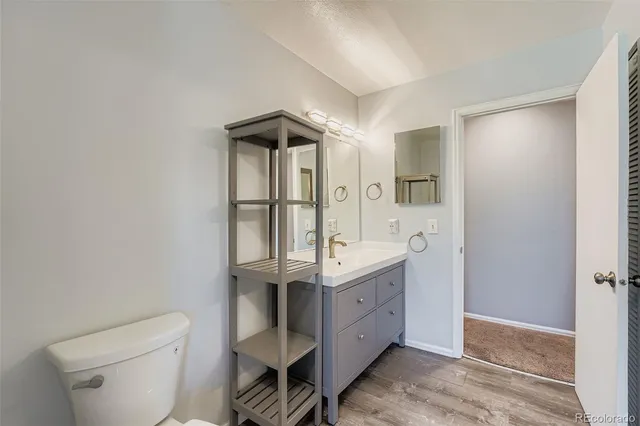 a bathroom with a granite countertop sink a toilet and shower
