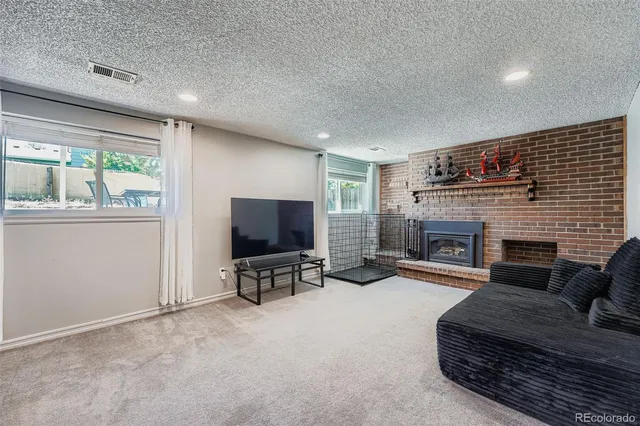 a living room with furniture a flat screen tv and a fireplace