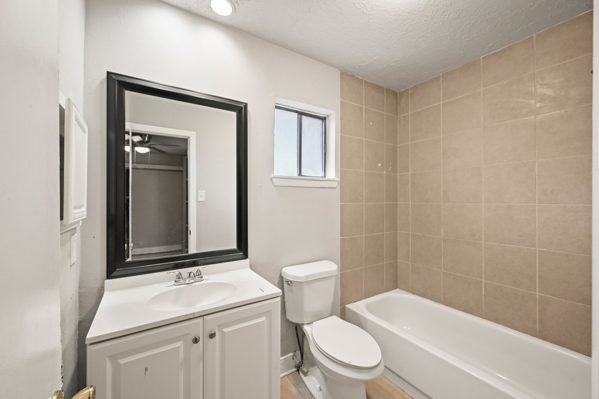 19302 Pocito Court Humble, TX 77346 - Photo 12 of 28 Primary bathroom with tub/shower combo, black framed mirror, medicine cabinet and sink.