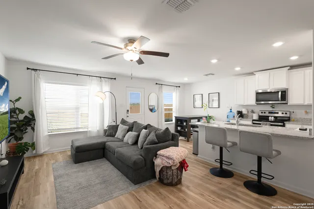 a living room with furniture flat screen tv and window