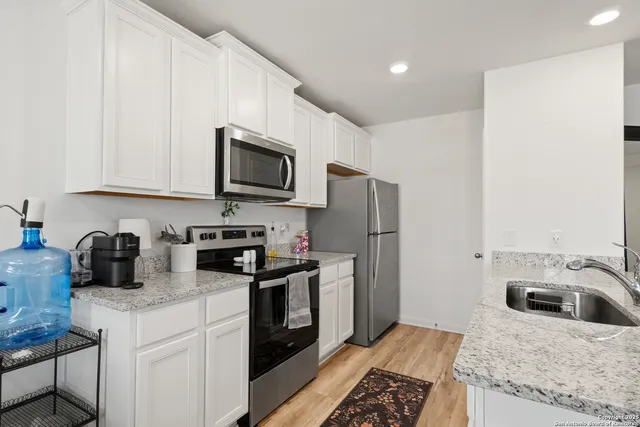 a kitchen with stainless steel appliances granite countertop a stove a sink dishwasher a refrigerator and a microwave