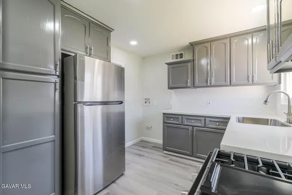 a kitchen with stainless steel appliances granite countertop a stove a sink and a microwave