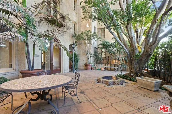 a view of a patio with couches and chairs under an umbrella