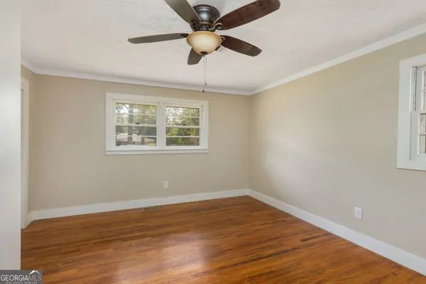 a view of an empty room with wooden floor