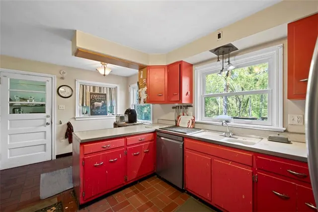a kitchen with a sink a window and cabinets