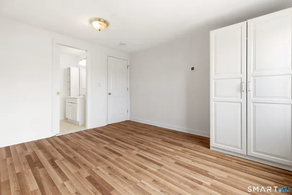 a view of empty room with wooden floor and cabinet