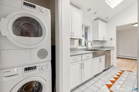 a kitchen with cabinets washer and dryer