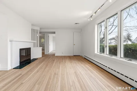 a view of a room with wooden floor and a fireplace