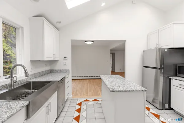 a kitchen with a sink a refrigerator and cabinets