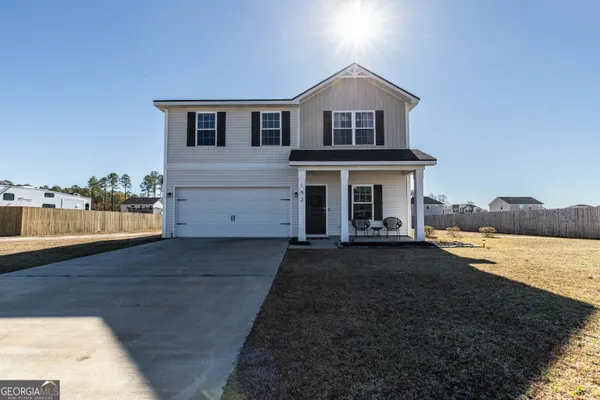 a front view of a house with a yard and lake view