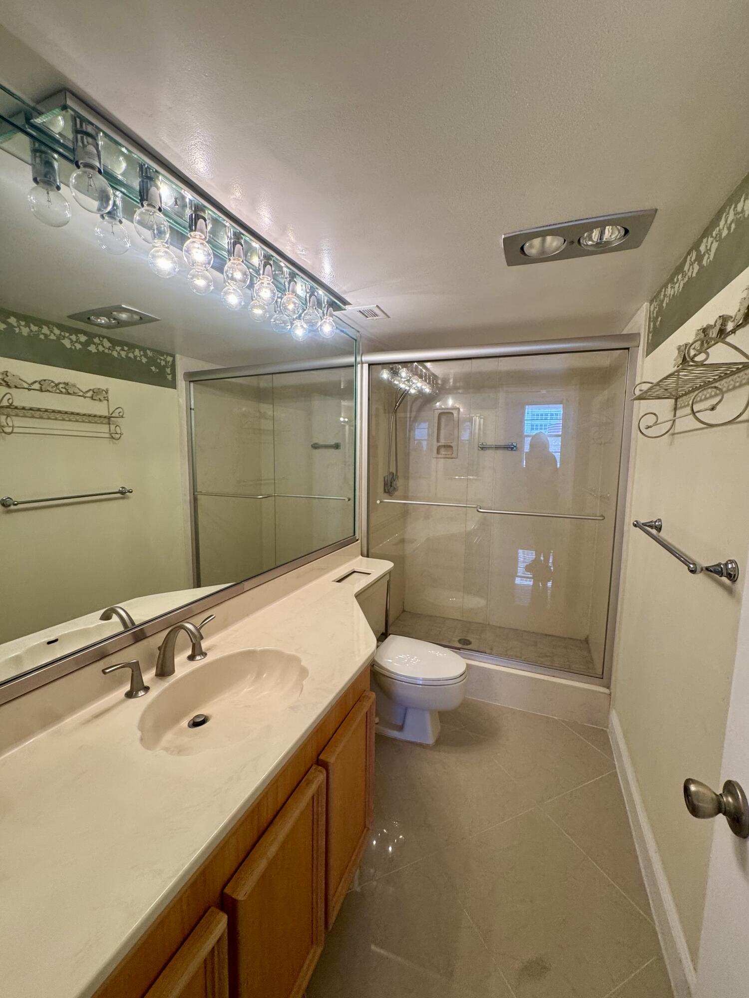 2851 South Ocean Boulevard, Unit 122 Boca Raton, FL 33432 - Photo 15 of 15 a bathroom with a sink mirror toilet and shower