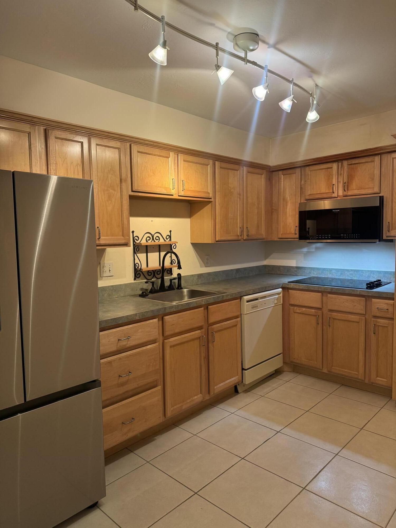2851 South Ocean Boulevard, Unit 122 Boca Raton, FL 33432 - Photo 3 of 15 a kitchen with stainless steel appliances granite countertop a refrigerator and a sink