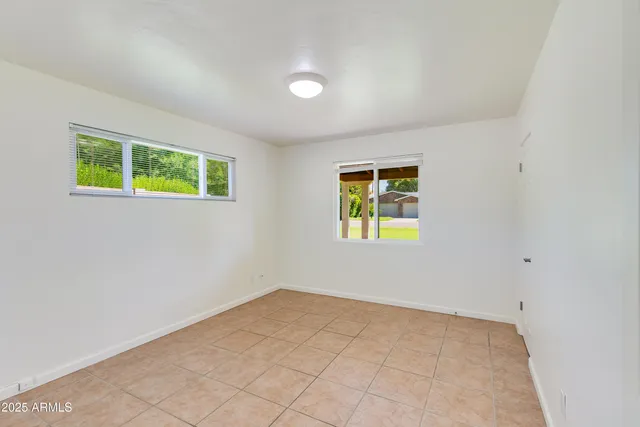 an empty room with windows and plants