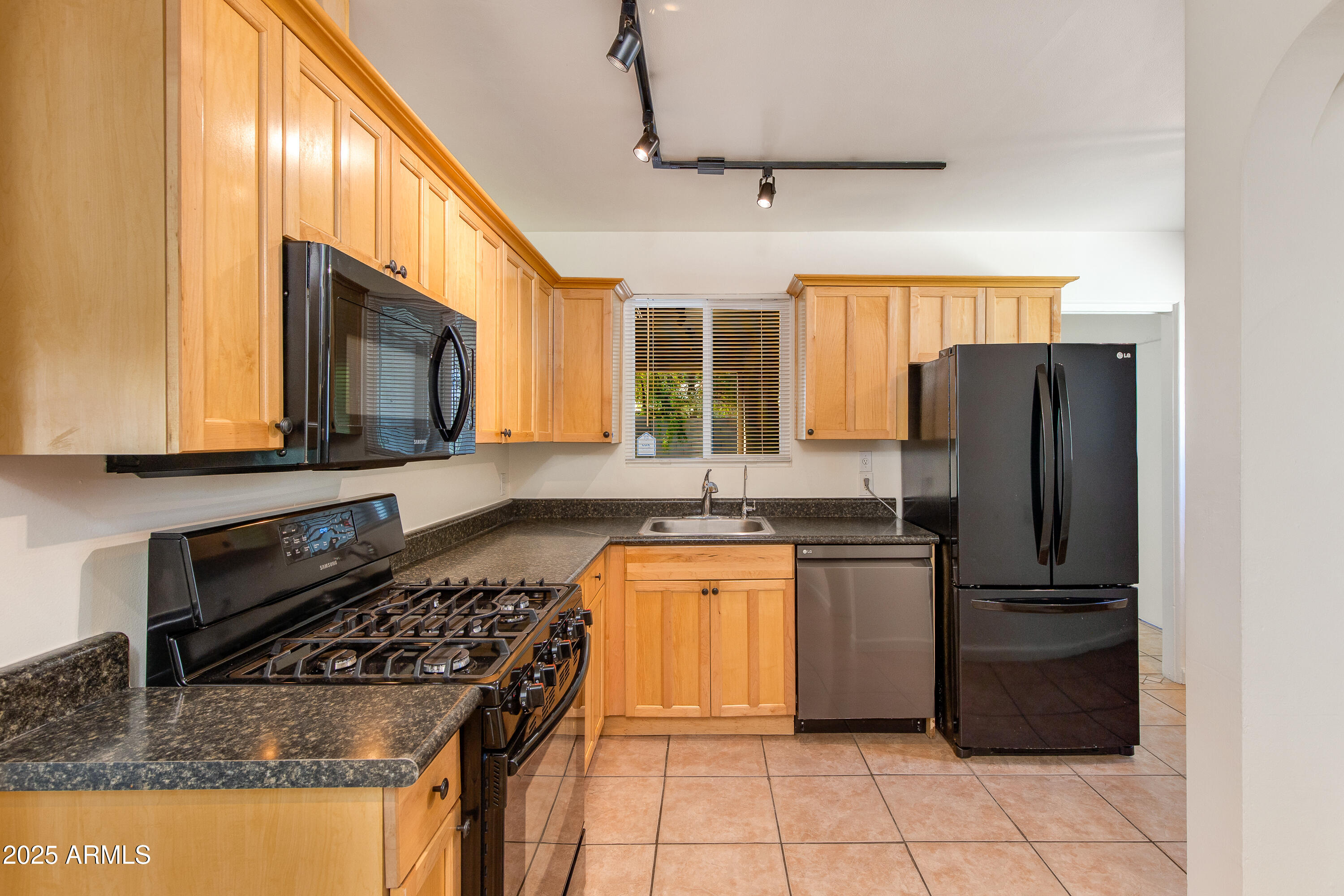 4808 North 29th Place Phoenix, AZ 85016 - Photo 4 of 18 a kitchen with stainless steel appliances granite countertop a refrigerator stove top oven and sink