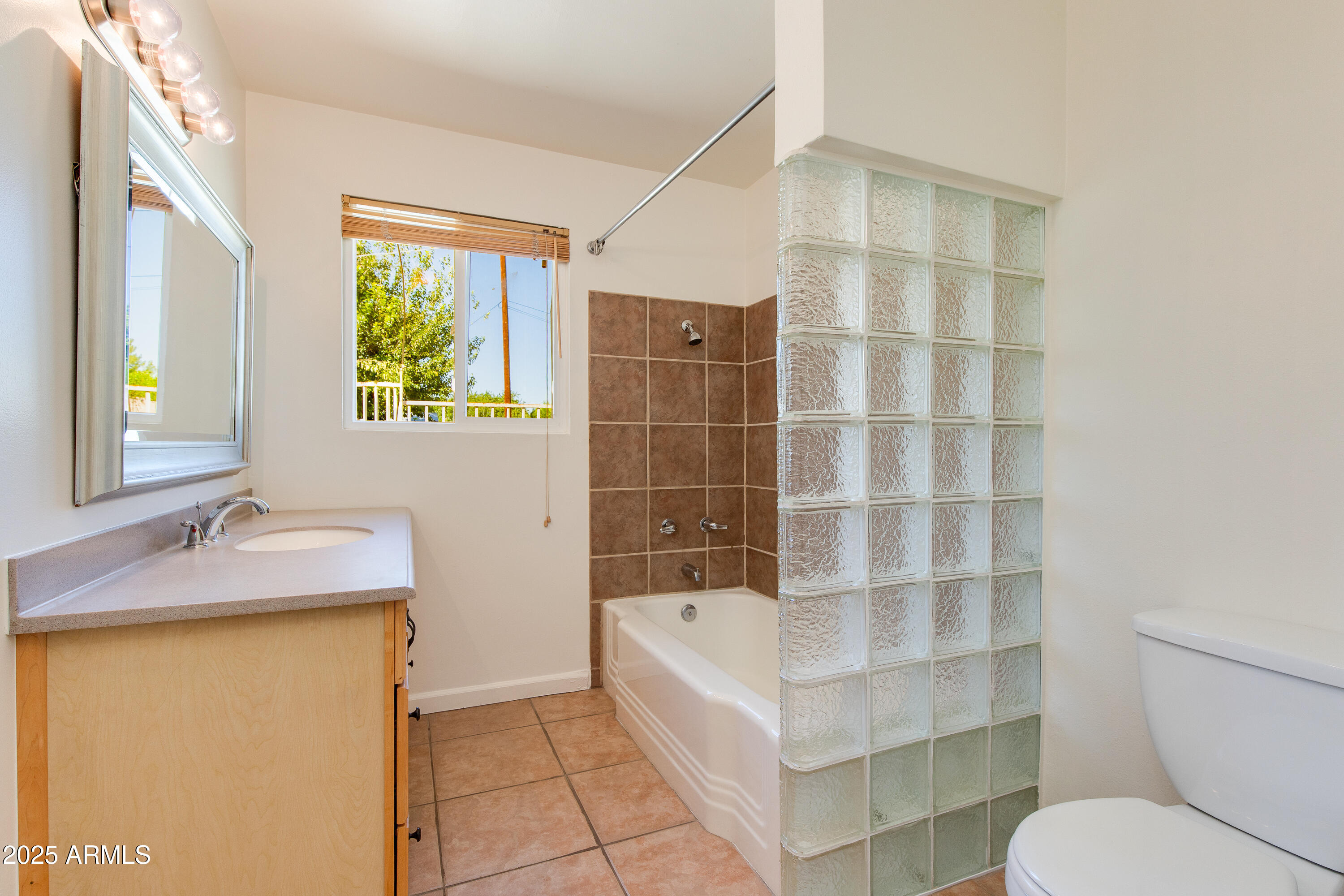 4808 North 29th Place Phoenix, AZ 85016 - Photo 9 of 18 a bathroom with a granite countertop sink toilet and shower