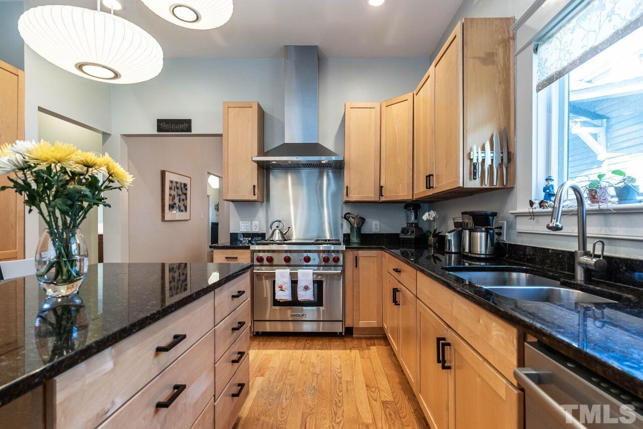 1210 Filmore Street Raleigh, NC 27605 - Photo 11 of 33 a kitchen with stainless steel appliances granite countertop a sink a stove and a wooden floors
