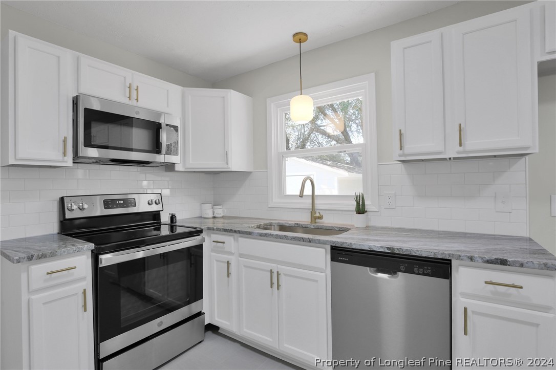 2714 George Owen Road Fayetteville, NC 28306 - Photo 5 of 12 a kitchen with granite countertop white cabinets white stainless steel appliances and a sink