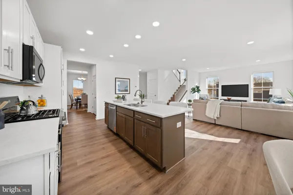 a large kitchen with stainless steel appliances lots of counter space and wooden floor
