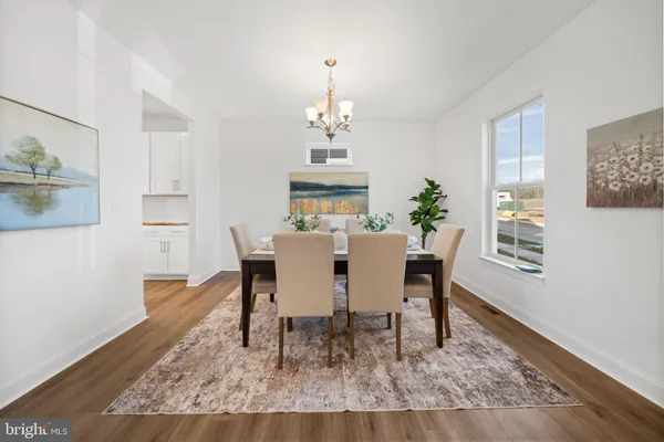 a dining room with wooden floor a chandelier a wooden table and chairs