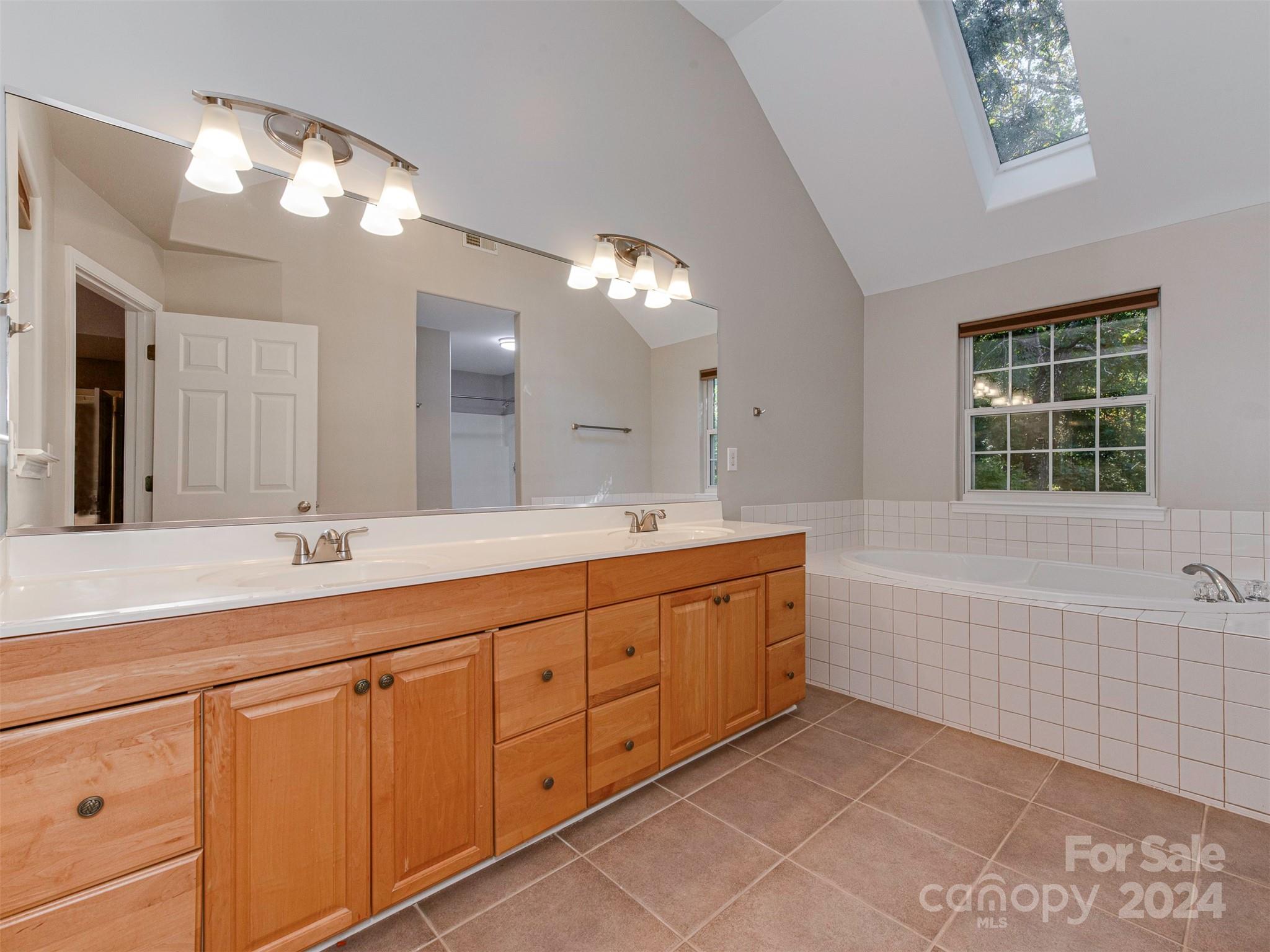 4801 Steepleton Way Charlotte, NC 28215 - Photo 11 of 28 a spacious bathroom with a granite countertop sink mirror and bathtub