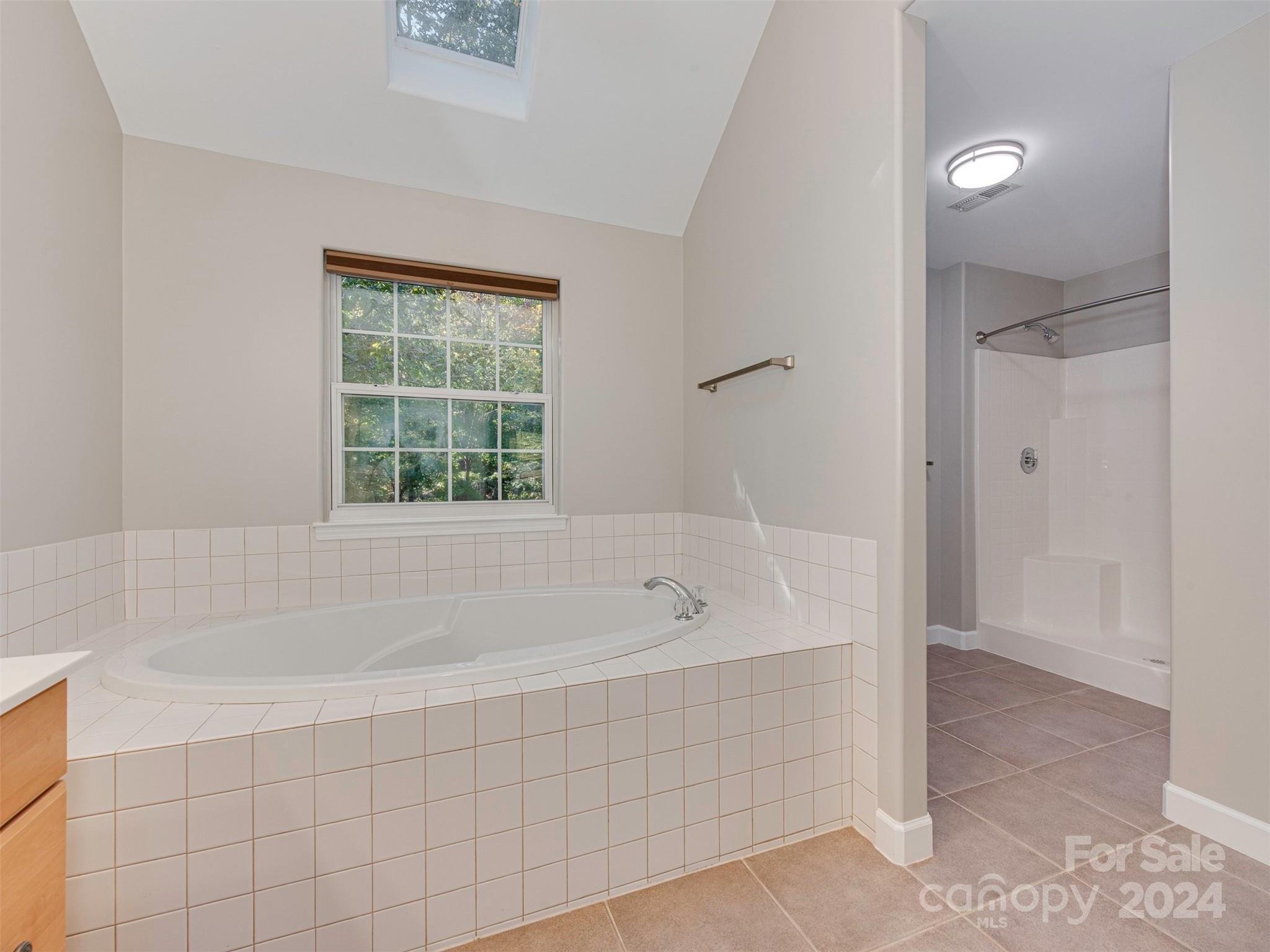 4801 Steepleton Way Charlotte, NC 28215 - Photo 12 of 28 a spacious bathroom with a bathtub and shower