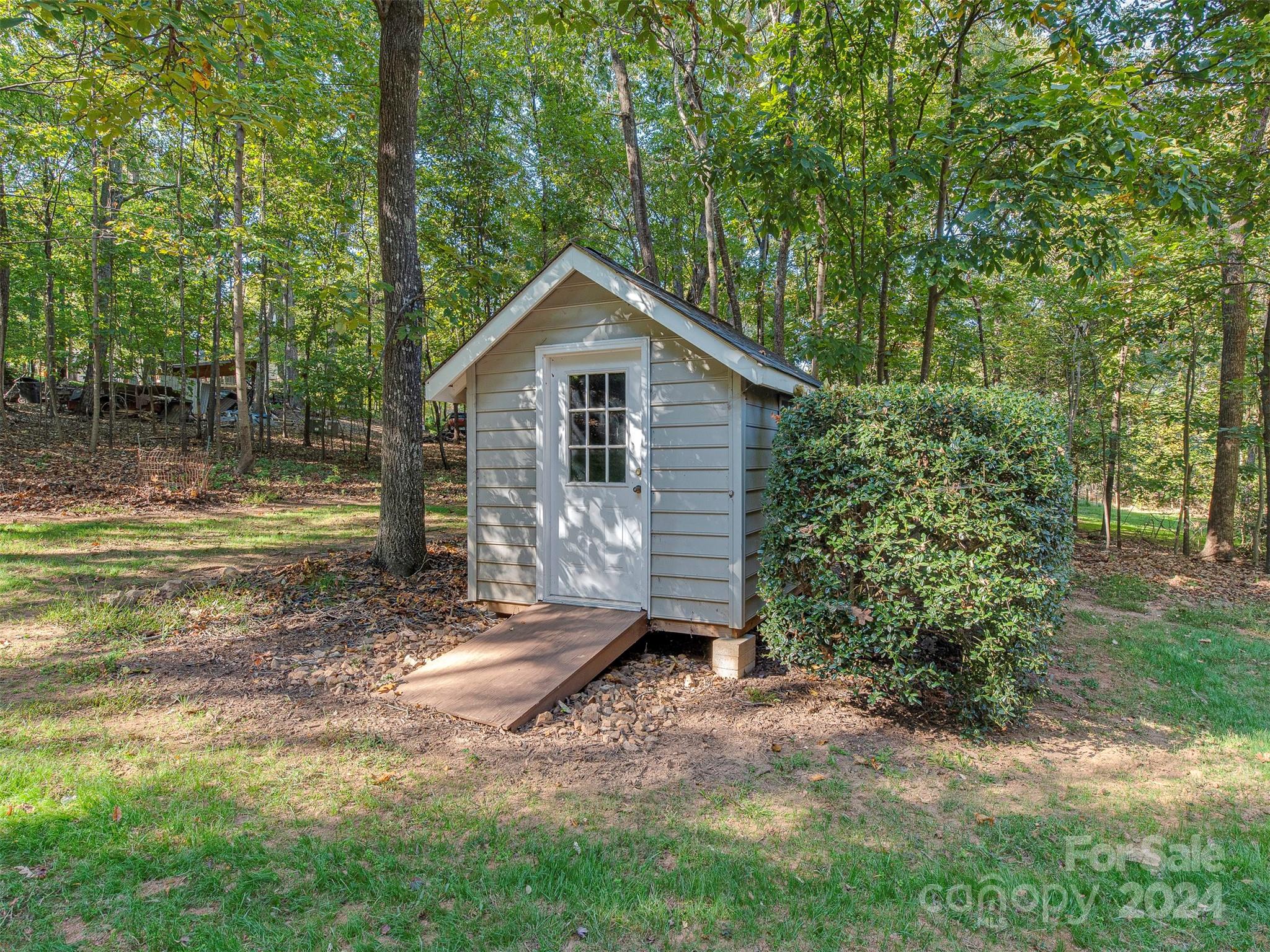 4801 Steepleton Way Charlotte, NC 28215 - Photo 23 of 28 a view of a small house with a small yard and large trees