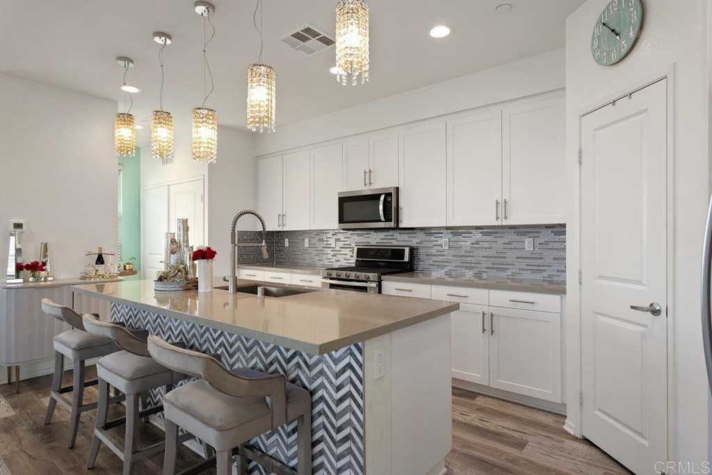 1267 Via Lucero Oceanside, CA 92056 - Photo 11 of 44 a kitchen with granite countertop a sink appliances cabinets and furniture