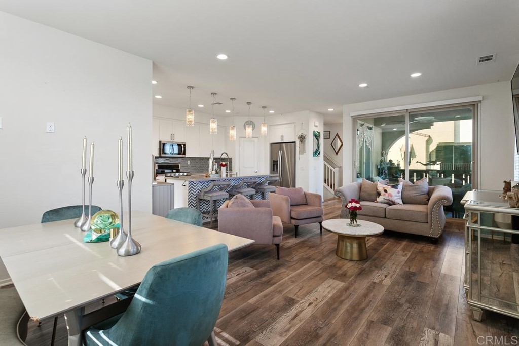 1267 Via Lucero Oceanside, CA 92056 - Photo 17 of 44 a living room with furniture kitchen view and a wooden floor