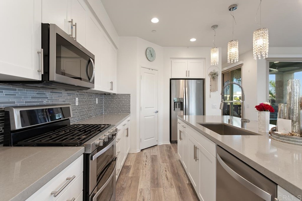 1267 Via Lucero Oceanside, CA 92056 - Photo 19 of 44 a kitchen with stainless steel appliances a sink stove and refrigerator