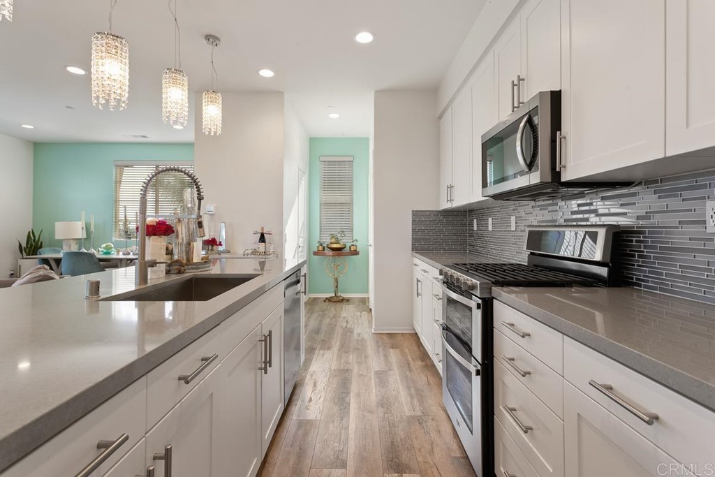 1267 Via Lucero Oceanside, CA 92056 - Photo 20 of 44 a large kitchen with stainless steel appliances granite countertop a lot of counter space and a sink