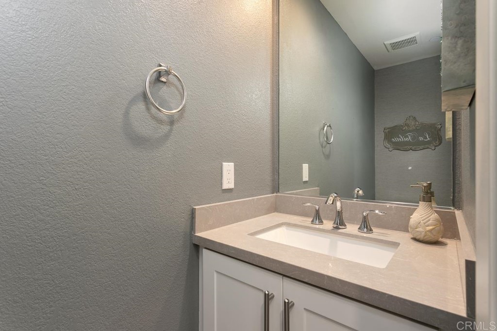 1267 Via Lucero Oceanside, CA 92056 - Photo 21 of 44 a bathroom with a granite countertop sink and a mirror