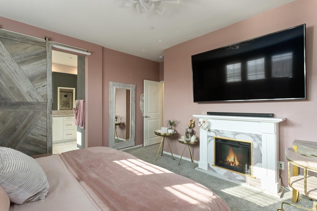 1267 Via Lucero Oceanside, CA 92056 - Photo 25 of 44 a living room with a fireplace and a flat screen tv