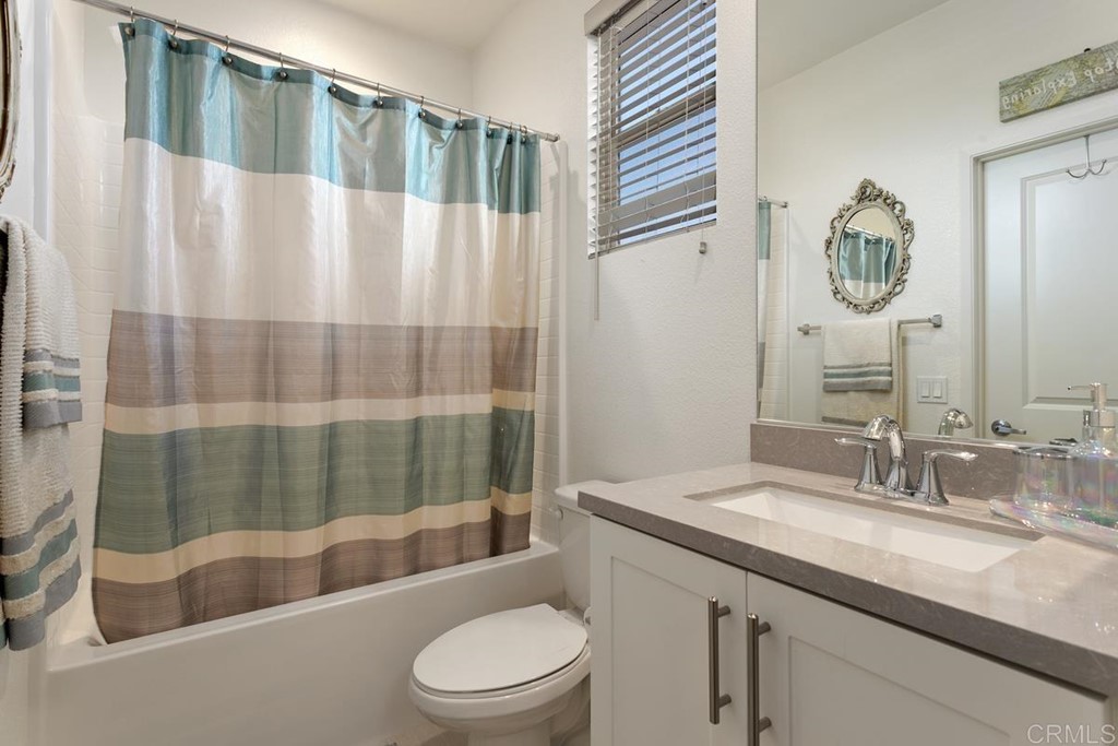 1267 Via Lucero Oceanside, CA 92056 - Photo 30 of 44 a bathroom with a granite countertop sink a toilet a mirror and shower