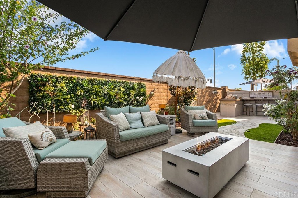 1267 Via Lucero Oceanside, CA 92056 - Photo 6 of 44 a view of a patio with couches table and chairs under an umbrella