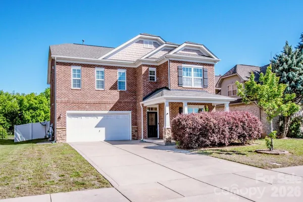 front view of a brick house with a yard