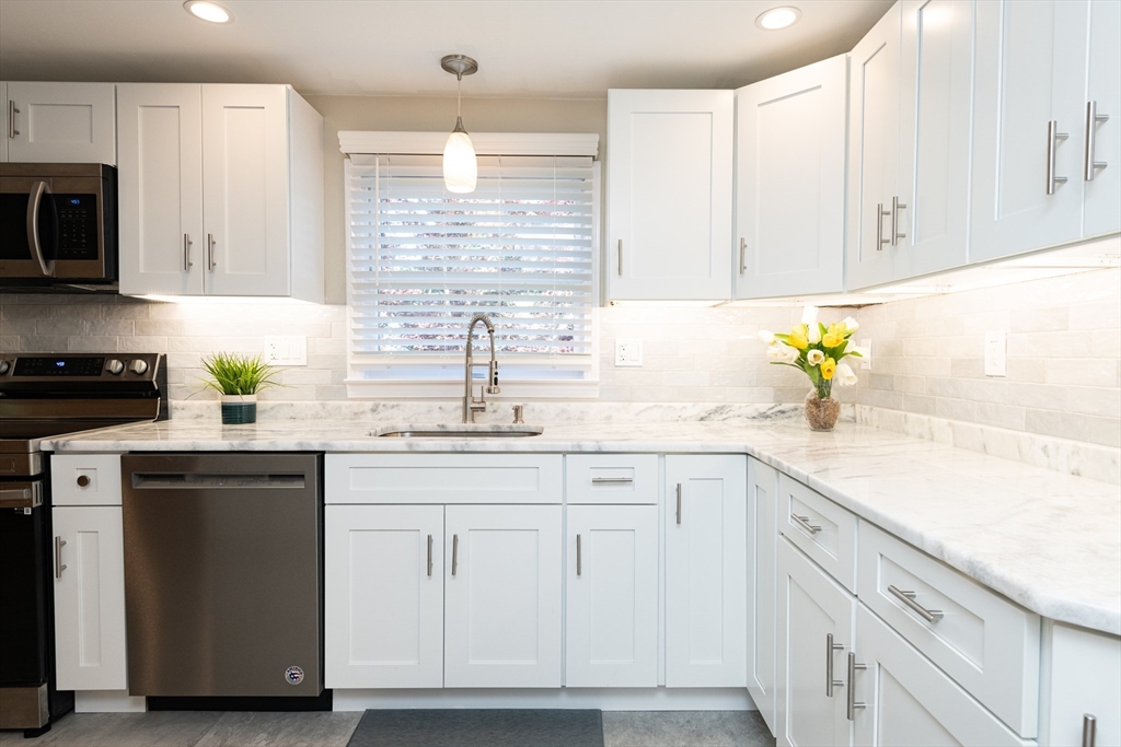 251 Centre Street Danvers, MA 01923 - Photo 14 of 42 a kitchen with white cabinets and a sink
