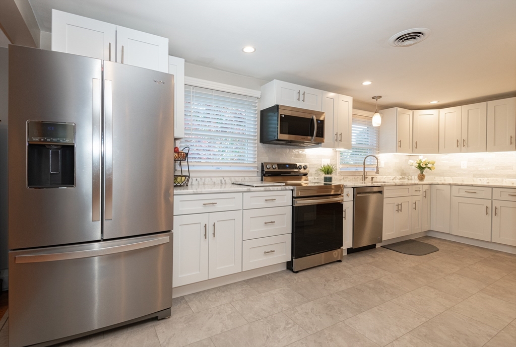 251 Centre Street Danvers, MA 01923 - Photo 15 of 42 a kitchen with white cabinets and stainless steel appliances