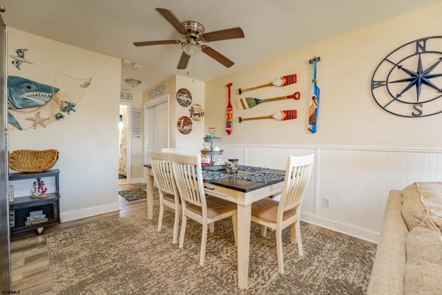 a view of a dining room with furniture and a chandelier fan