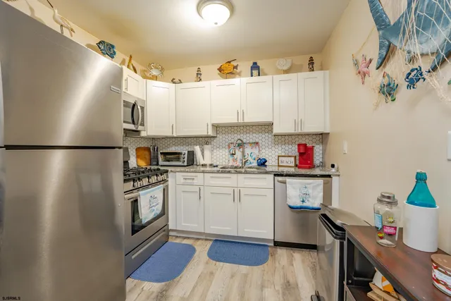 a kitchen with granite countertop a sink stainless steel appliances and cabinets
