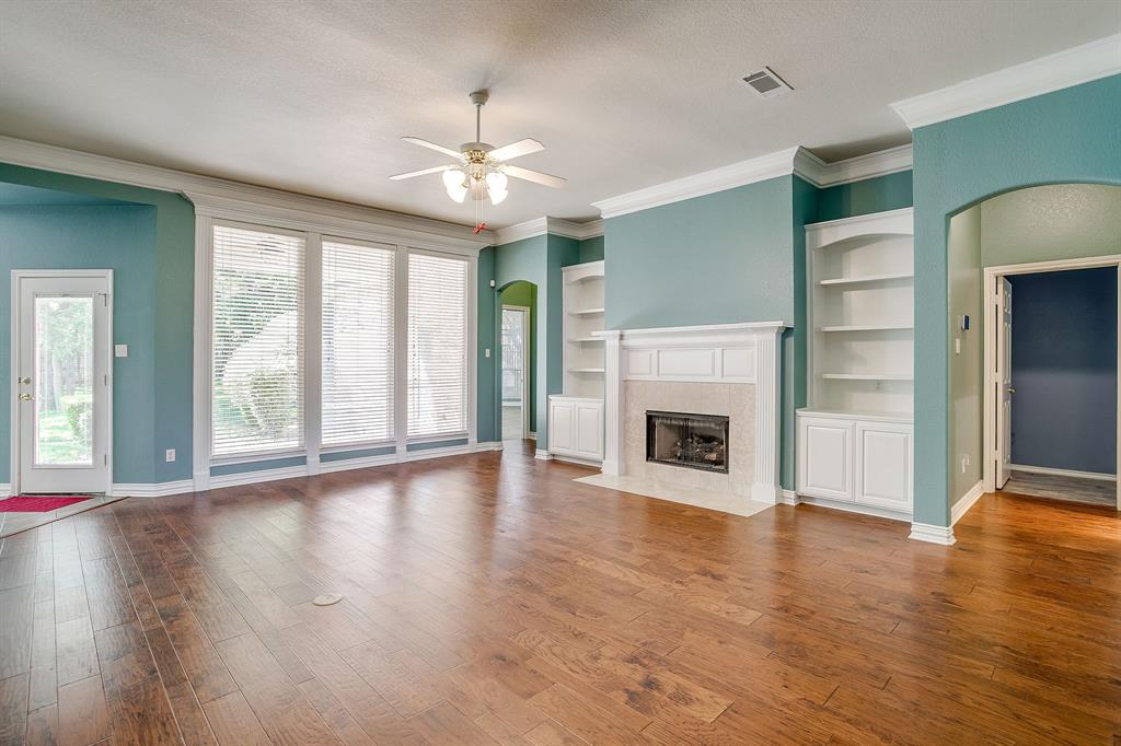 312 Oak Ridge Drive Burleson, TX 76028 - Photo 12 of 40 an empty room with wooden floor fireplace and windows