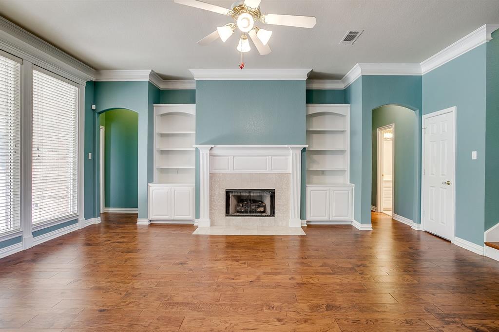 312 Oak Ridge Drive Burleson, TX 76028 - Photo 13 of 40 an empty room with wooden floor a fireplace and entryway