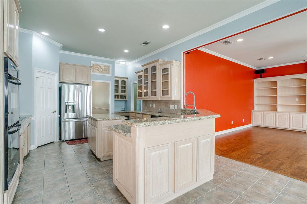 312 Oak Ridge Drive Burleson, TX 76028 - Photo 17 of 40 a kitchen with stainless steel appliances granite countertop a sink and a refrigerator