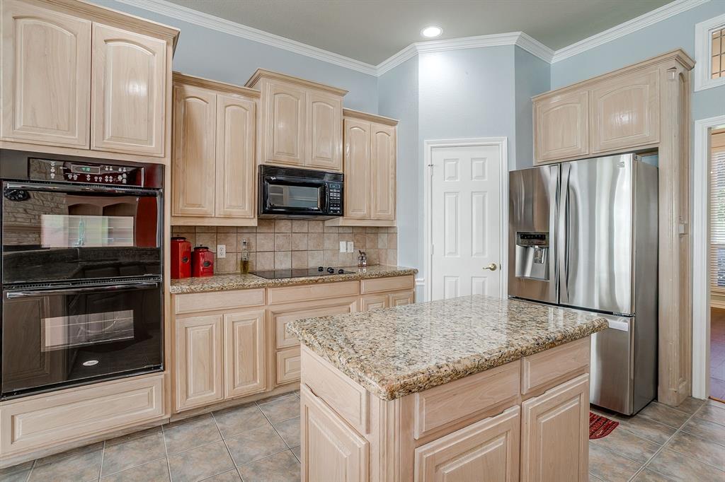 312 Oak Ridge Drive Burleson, TX 76028 - Photo 19 of 40 a kitchen with stainless steel appliances granite countertop a refrigerator stove and microwave