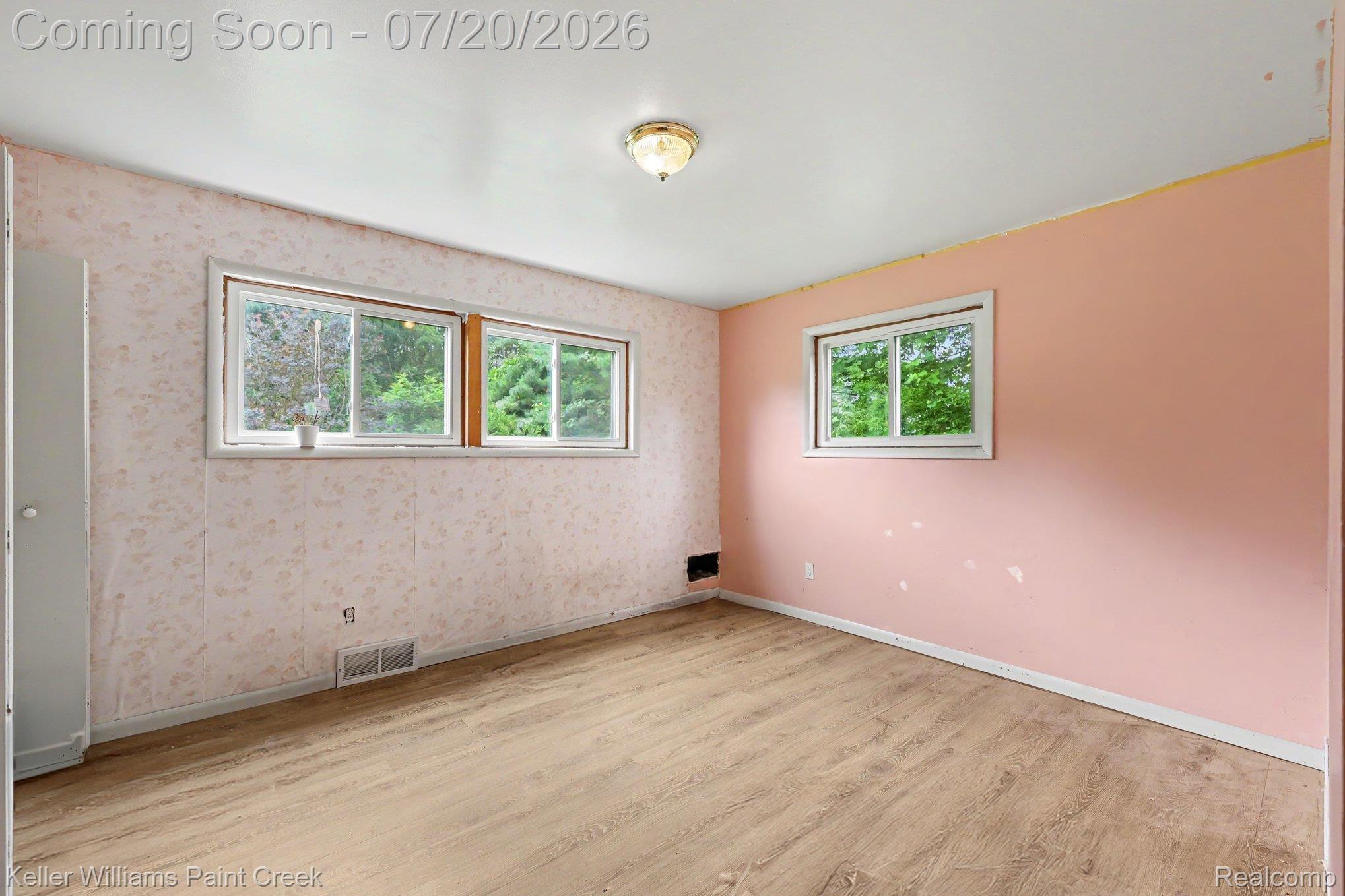 1371 East Leonard Road Leonard, MI 48367 - Photo 11 of 32 Room featuring two windows, wood-finish flooring, and a ceiling-mounted light fixture