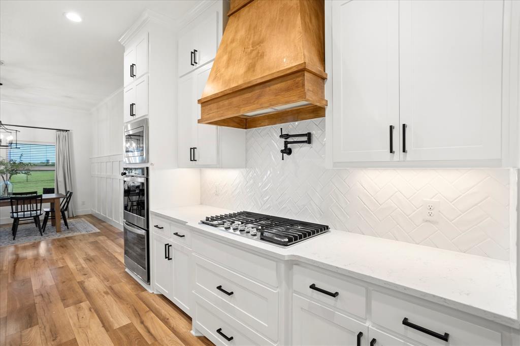 1074 Pioneer Crossing Weatherford, TX 76088 - Photo 13 of 36 a kitchen with a sink a stove and cabinets